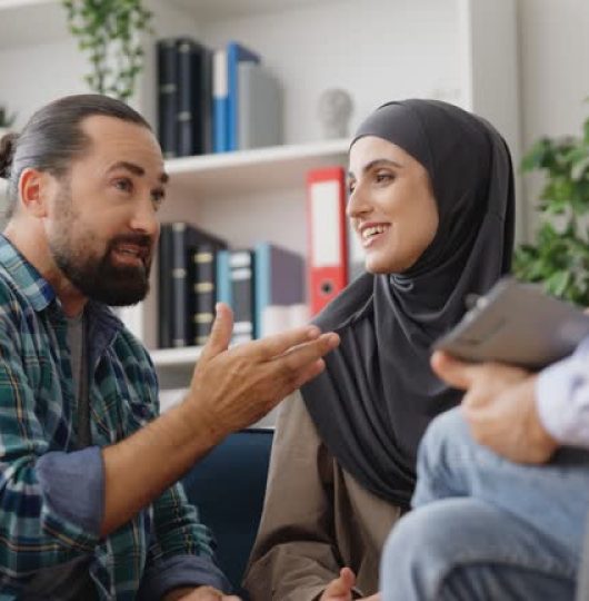 Smiling muslim couple talking during psychotherapist session, couples therapy